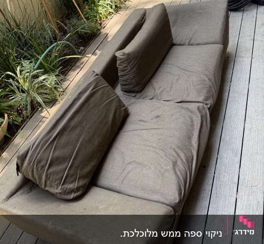 ספה חיצונית על דק עץ עם צמחייה מסביב